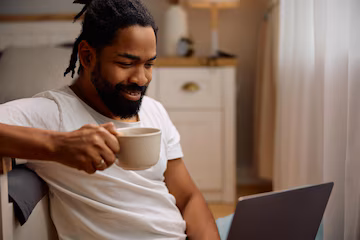 Person relaxing with laptop and coffee